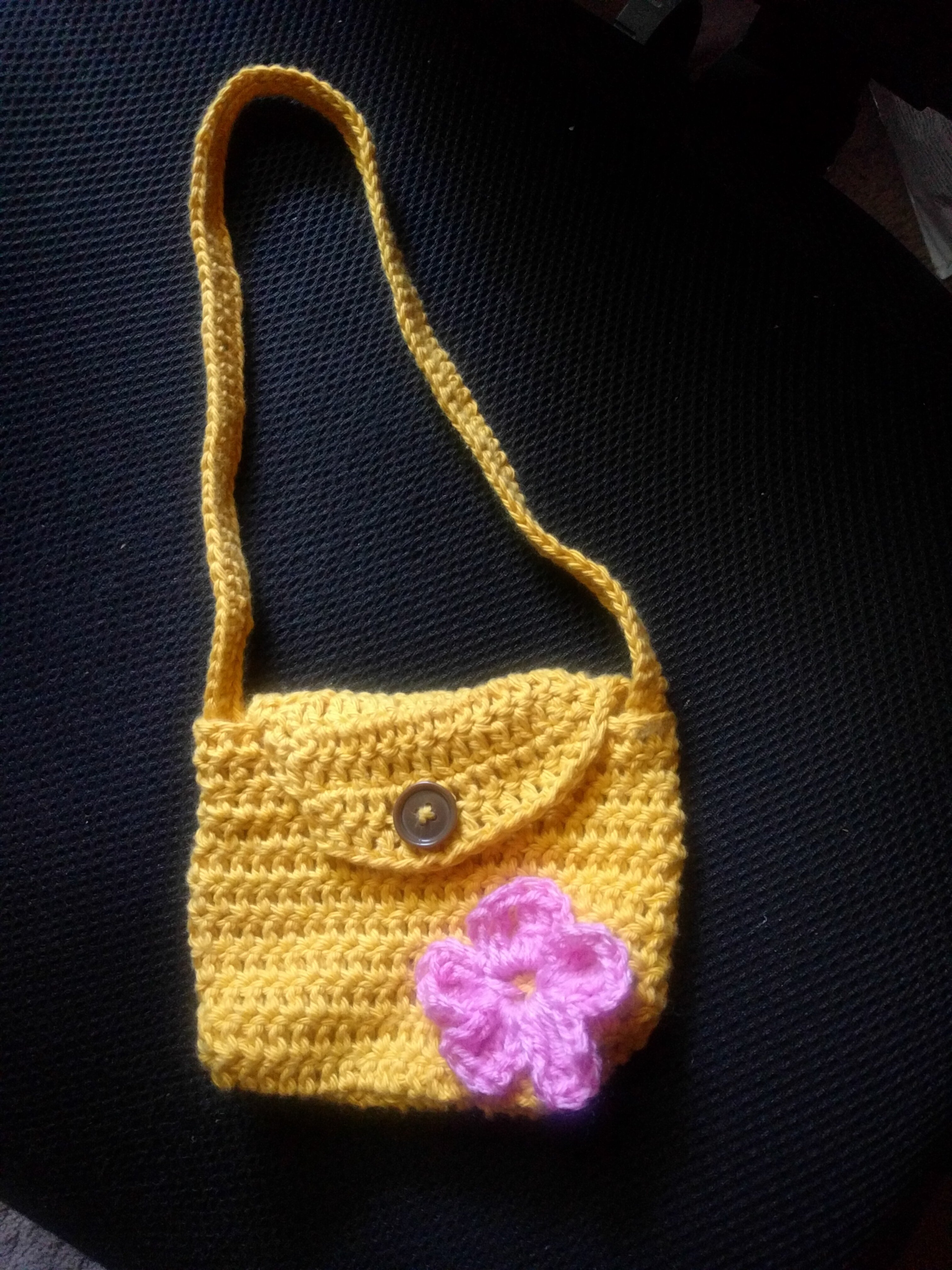 A yellow crocheted purse sized for a small child