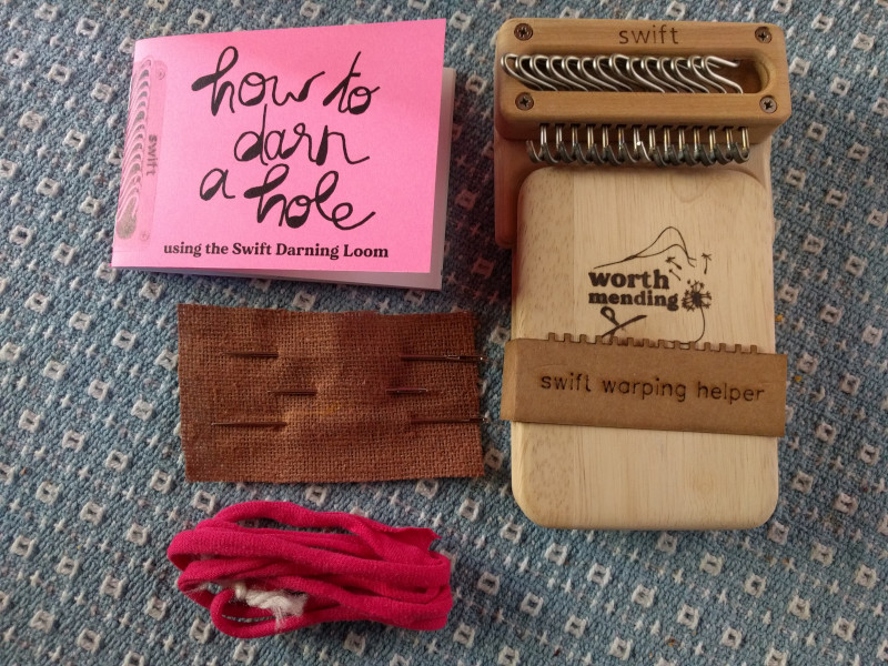 A darning loom, needles, instruction booklet, and tie cord